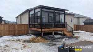 Black studio sunroom with treated wood deck and black aluminum railings, Stonewall, Manitoba 2
