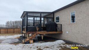 Black studio sunroom with treated wood deck and black aluminum railings, Stonewall, Manitoba 3